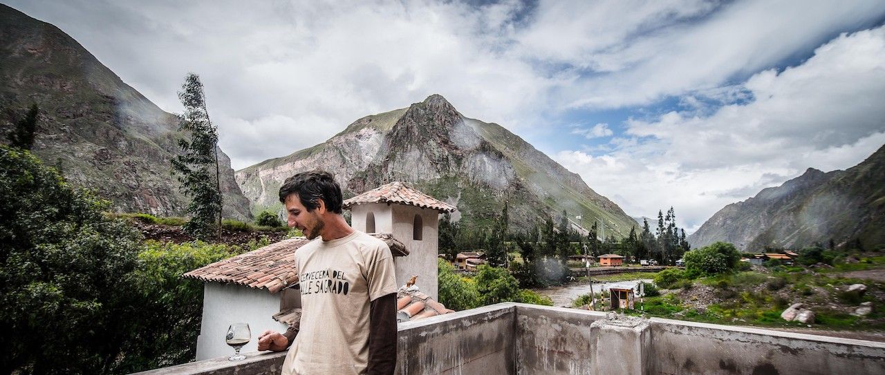 Maestro cervecero en la Cervecería del Valle en el Valle Sagrado de Perú, elaborando cervezas artesanales rodeado de montañas andinas.
