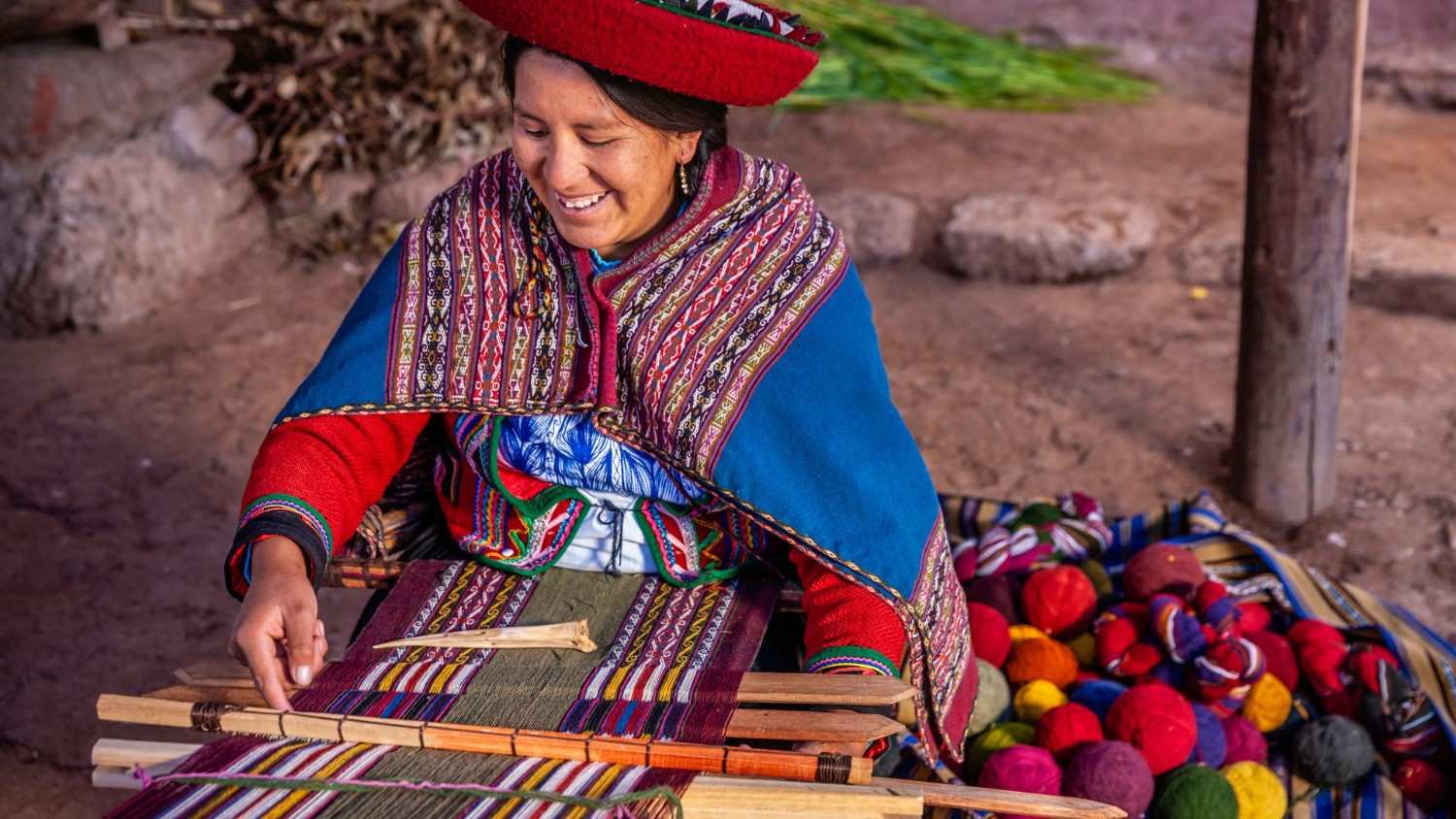 Quechua woman weaving traditional Andean textiles in Chinchero, Sacred Valley, Peru – colorful yarns and intricate patterns on a backstrap loom.