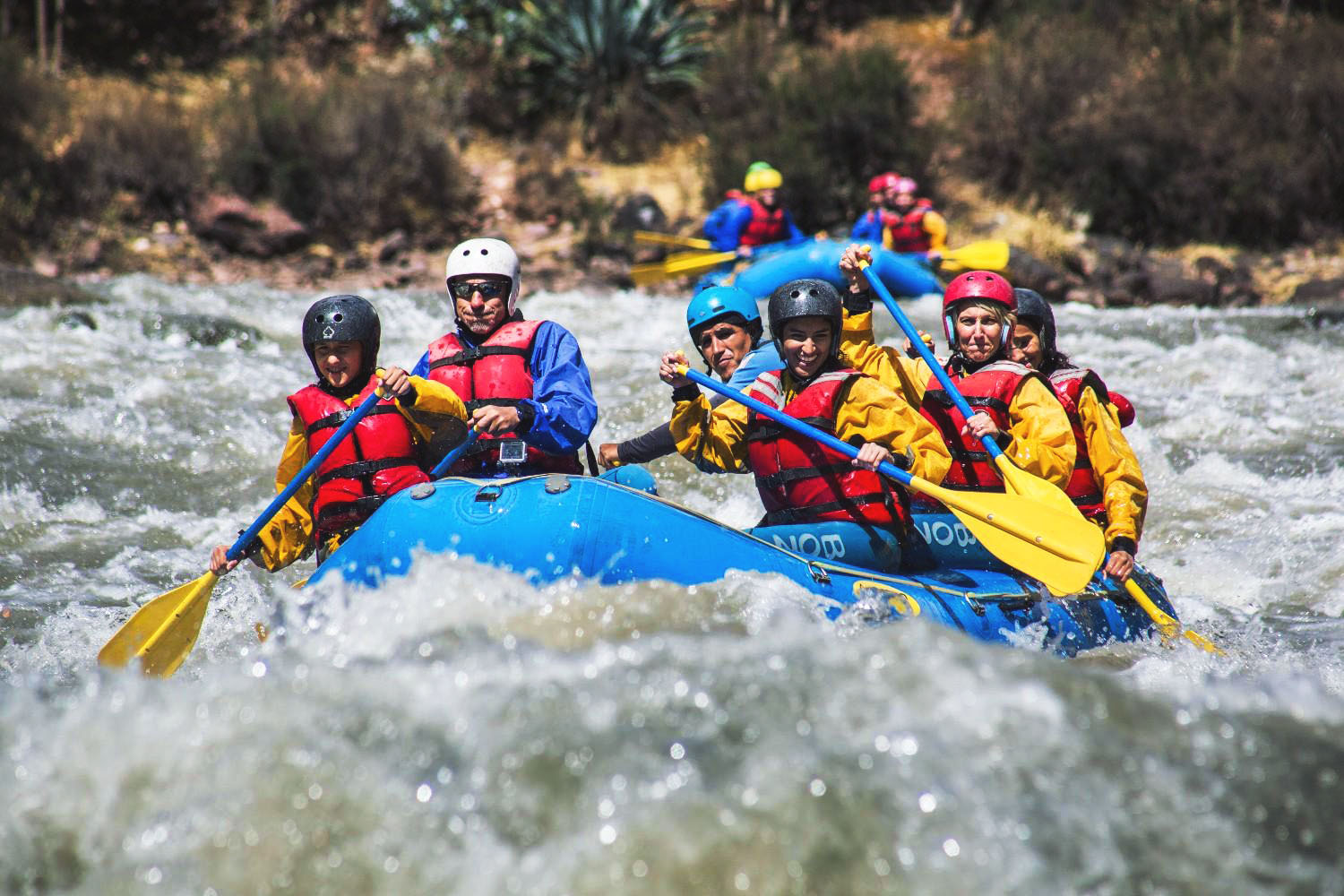 Group of adventurers rafting on the rapids of the Urubamba River in the Sacred Valley of the Incas – adventure tourism and water sports in the Peruvian Andes.