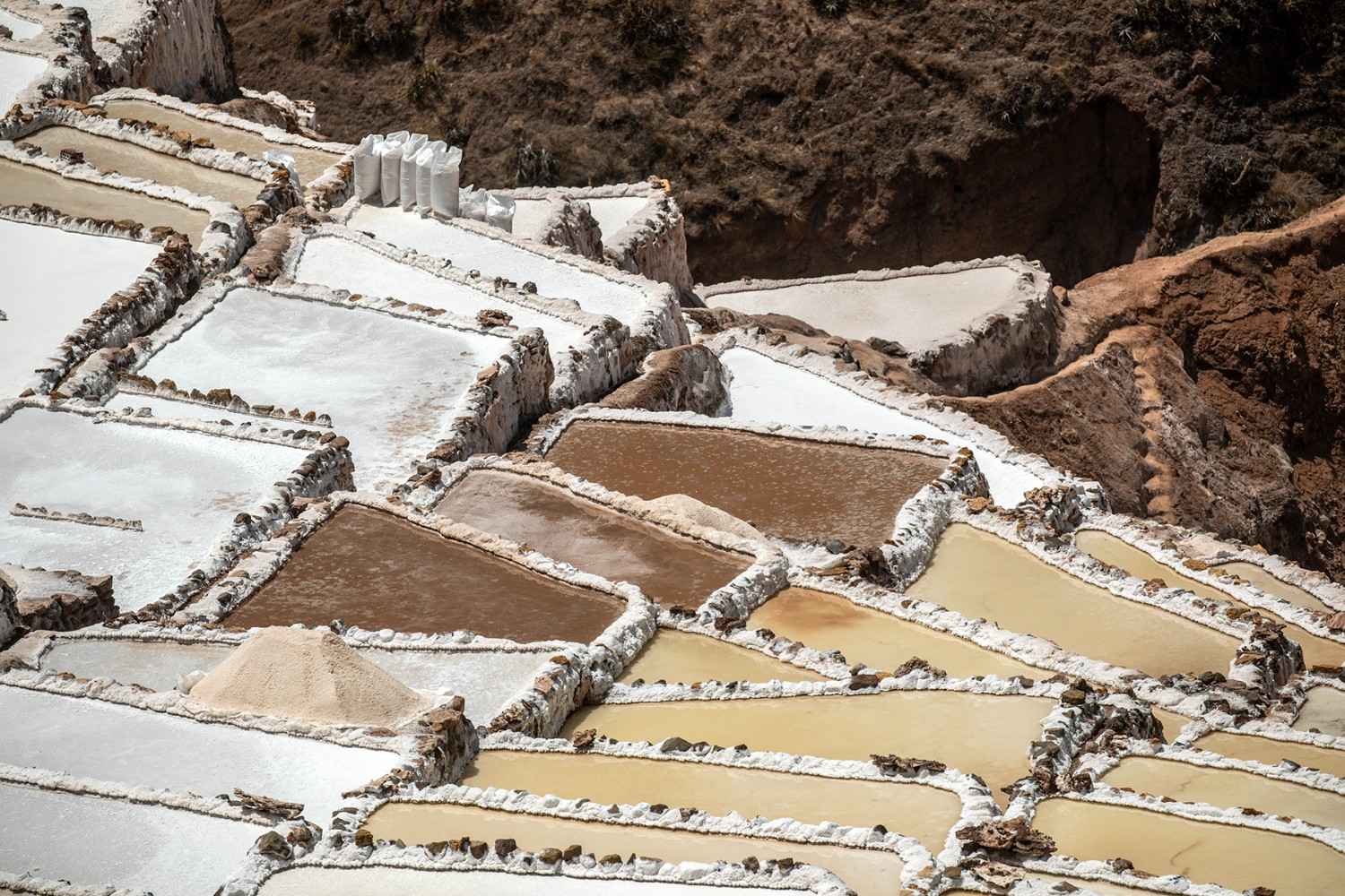 Close-up view of the Maras Salt Mines in the Sacred Valley of the Incas, featuring salt terraces in use since pre-Inca times – cultural tourism and photography in the Peruvian Andes.