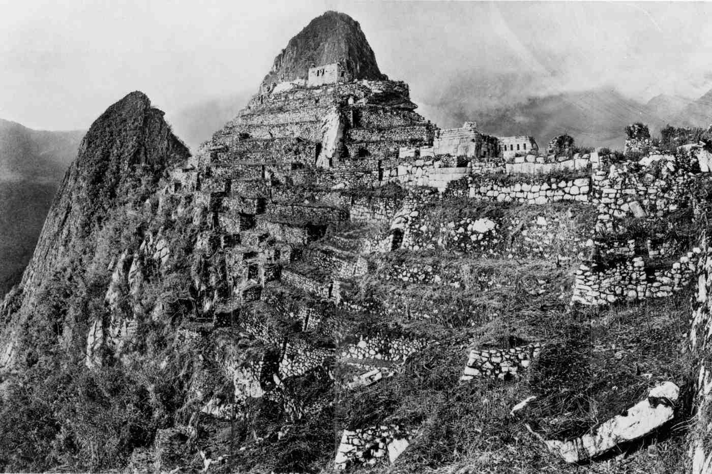 Fotografía temprana de Machu Picchu tomada por Hiram Bingham tras la primera gran excavación, mostrando terrazas y estructuras de piedra parcialmente despejadas de la vegetación selvática.