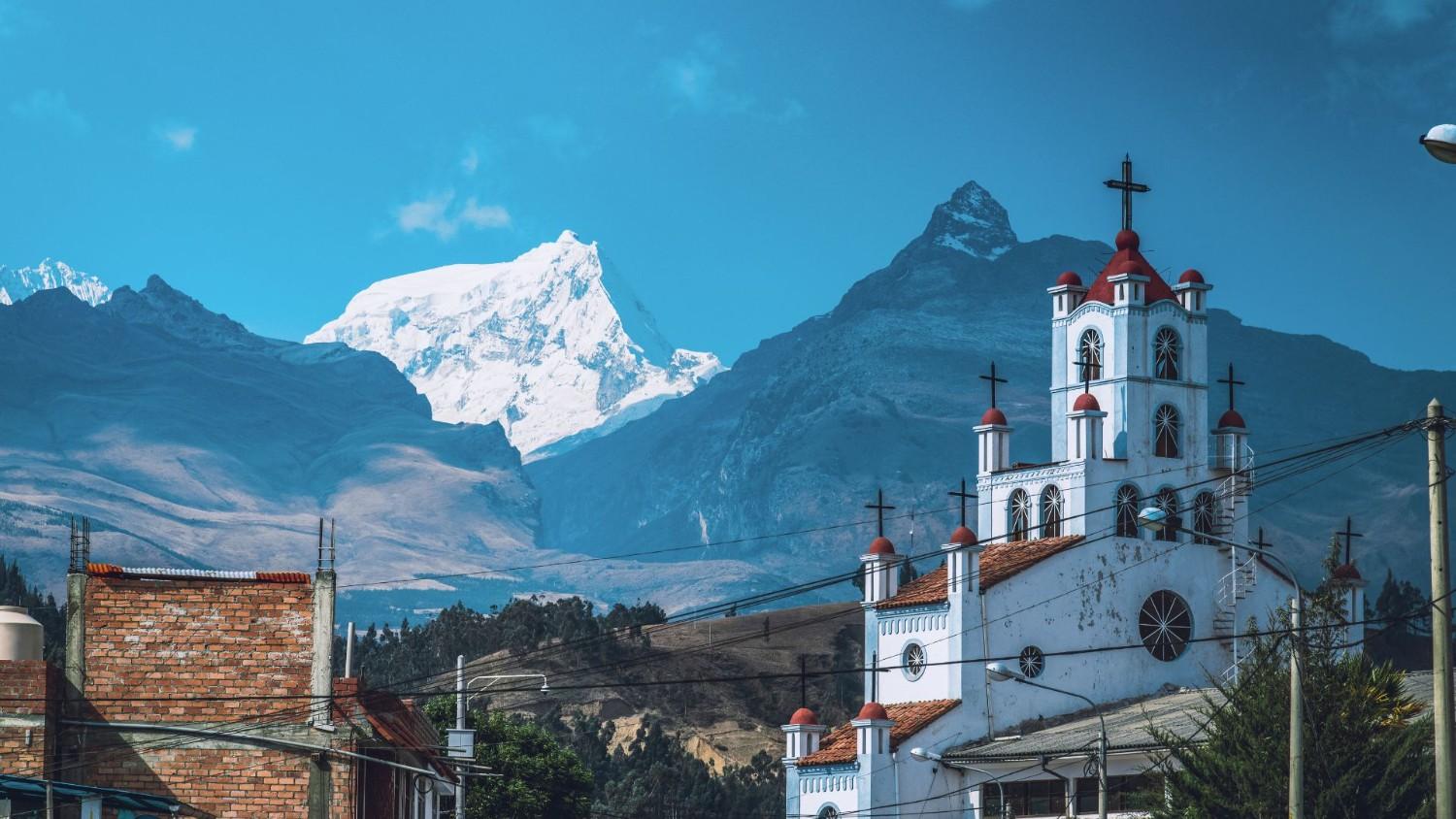 Iglesia de la Soledad in Huaraz, Peru, with the snow-capped peaks of the Cordillera Blanca in the Andes Mountains – top sight to visit in Huaraz.